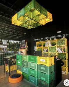 the interior of a store with green and yellow crates hanging from it's ceiling