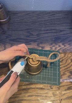 a person using scissors to cut rope on a piece of wood with a grinder