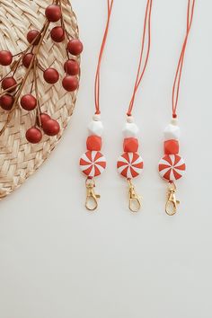 three red and white candy lollipops are on a straw hat next to some other items