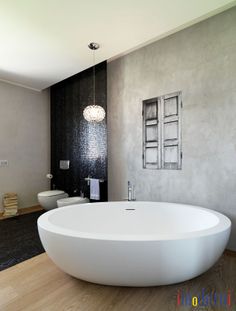 a large white bath tub sitting on top of a wooden floor