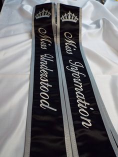 Pageant sash / Black satin and white satin / silver gray trim and thread / script font and Daily font / Silver Metallic Crowns on shoulder Optional / If you would like to add a name on the back there is a added fee of $14.00 to add first and last name Please contact us before you place your order ...thank you theses' sashes or custom made to order for your / Drill Team / Schools / Bands / Clubs / events / Pageant shows/and much much more Remember the more lettering you put on the sash will depen Sash Design Ideas Pageant, Cheap Satin Sashes For Graduation, Prom Sashes Titles, Sash For Pageant, Prom Sash, Elegant Silver Bedazzled Sashes, Silver Embroidered Sash For Party, Prom Queen Sash, Sash Design