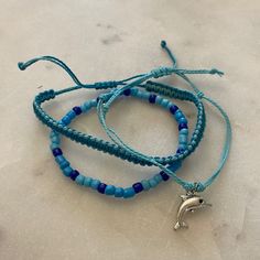 Set Of 3 Bracelets With Dolphin Charm 6.3-10 Inch Circumference Waterproof And Fade Proof! Blue Hypoallergenic Bracelets For Beach, Trendy Adjustable Light Blue Beaded Bracelets, Trendy Adjustable Light Blue Bracelet, Casual Blue Braided Bracelets, Trendy Blue Braided Bracelet With Sliding Knot, Casual Blue Hypoallergenic Jewelry, Blue Hypoallergenic Friendship Bracelets For Beach, Adjustable Trendy Blue Bracelets, Trendy Adjustable Blue Bracelets