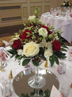 a centerpiece with roses and other flowers on a table