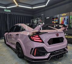 the rear end of a pink car parked in a garage