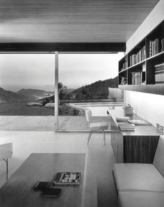 a living room filled with furniture next to a large glass window covered in bookshelves