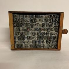 a wooden frame with letters and numbers on the front is made out of old newspapers