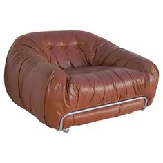 a brown leather chair sitting on top of a white floor