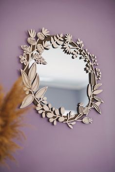 a mirror that is on the wall next to a plant