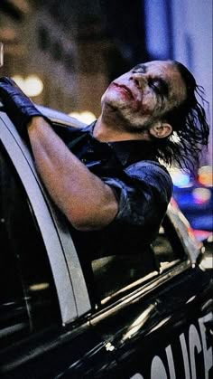 a man with his head out the window of a police car