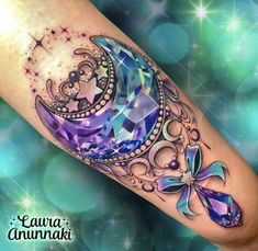 an artistic tattoo on the leg of a woman with a crescent and stars around it