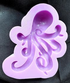 an octopus shaped soap mold sitting on top of a black surface