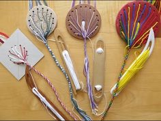 several craft items are laid out on a table with string and paper attached to them