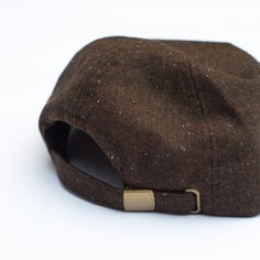 a brown hat with a hole in the middle on a white background, it appears to be an unbuttoned cap