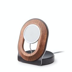 an electronic device with a wooden stand on it's side and a white light in the middle