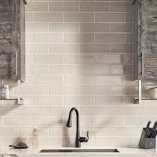 a kitchen with white counter tops and black faucet, sink and shelves on the wall