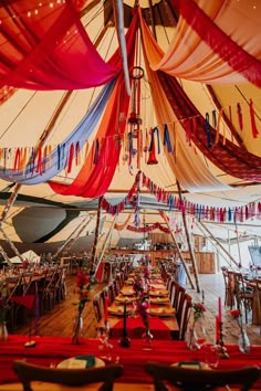 the inside of a large tent with tables and chairs set up for a dinner party