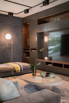 a living room filled with furniture and a flat screen tv mounted on a wall above a coffee table