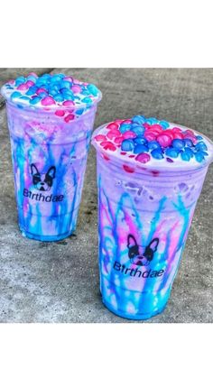 two plastic cups with blue, pink and purple swirls on the bottom one is filled with candy