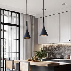 a kitchen with white cabinets and black pendant lights