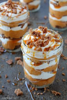 three desserts in small glass jars with toppings on the top one is topped with whipped cream and caramel