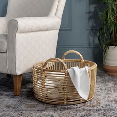 a wicker basket sitting on the floor next to a chair and potted plant