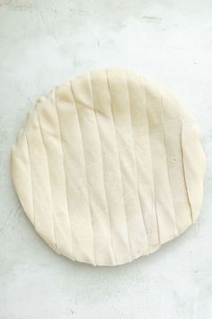 an uncooked pizza dough on a white surface