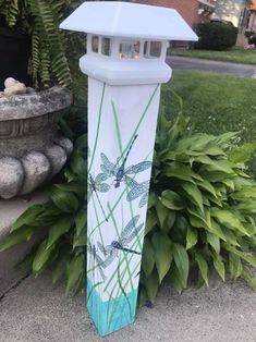 a blue and white lamp sitting next to a planter with dragonflies on it