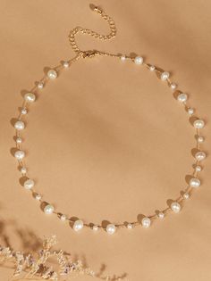 Enhance your neckline with the elegance of this dainty choker necklace. Featuring a delicate line of pearl stones in various sizes, it exudes timeless beauty and sophistication. Pearl Choker Necklace For Wedding, Wedding Pearl Choker Chain Necklace, Elegant Pearl Choker Necklace With Clavicle Chain, Pearl Choker For Wedding, Elegant Pearl Choker With Clavicle Chain, Chic Pearl Chain Choker, Adjustable Pearl Embellished Choker Necklace, Pearl Chain Bridal Choker Necklace, Pearl Chain Bridal Choker