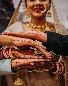 two brides holding hands with henna written on them