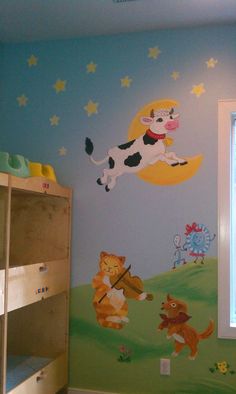 a child's bedroom with a cow theme painted on the wall