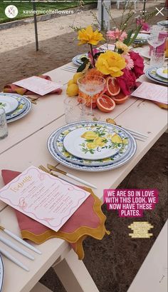 a table set up with plates and place settings for an outdoor dinner or brunch party