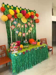 a table topped with lots of green grass covered in pom poms and decorations