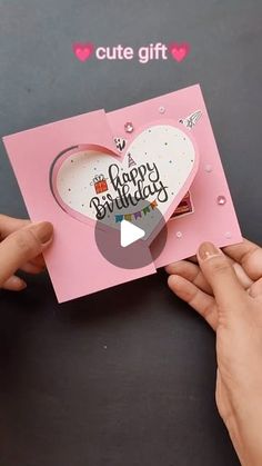 someone is holding up a card that says happy birthday with a heart cut out on it