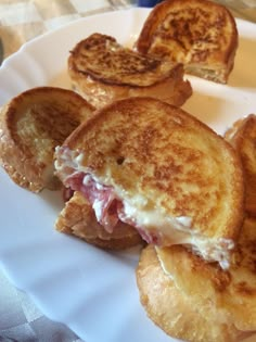 there is a sandwich on a white plate with some toasted bread in the background