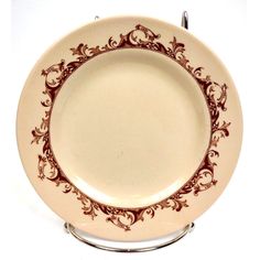 a plate with an ornate design on the rim is shown in red and gold colors