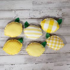 four yellow and white pillows sitting on top of a wooden floor next to each other