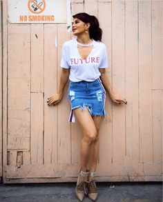 a woman leaning against a wall with her hands on her hips wearing a t - shirt that says future