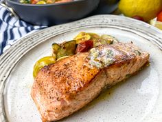 a white plate topped with salmon and vegetables