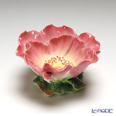 a pink flower sitting on top of a white table