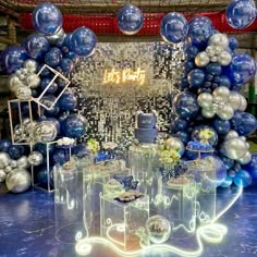 blue and silver balloons are on display in front of a mirror wall with the words let's party