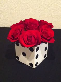 a white and black box with red roses in it