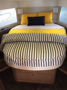 a bed with yellow and black pillows on it