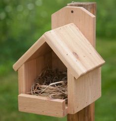 a wooden birdhouse with a nest in it