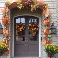 the front door is decorated with orange and yellow flowers, pumpkins and burlocks