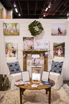 a room with pictures and photos on the wall above a coffee table in front of a mirror