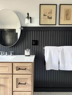 a bathroom with two white towels hanging on the wall next to a sink and mirror