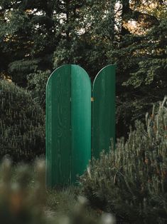 there are two green posts in the middle of some bushes