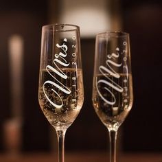 two wine glasses sitting on top of a table next to each other with the word love spelled in cursive writing