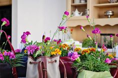 three purses with flowers in them sitting on a table