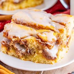 two slices of cinnamon roll cake on a white plate with icing drizzled over them